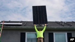 Nicholas Hartnett, chủ sở hữu của Pure Power Solar, đang lắp một tấm pin mặt trời lên mái nhà ở Frankfort, Kentucky, ngày 17/7/2023. Mỹ nhập phần lớn pin mặt trời từ Việt Nam, Malaysia, Campuchia và Thái Lan.