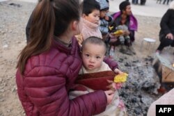 Çin'in Gansu eyaletinde meydana gelen deprem sonrası soğuk hava nedeniyle depremzedeler ısınmaya çalışıyor.