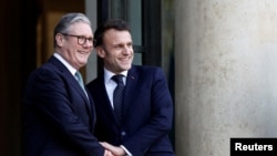 French President Emmanuel Macron, right, welcomes Britain's Prime Minister Keir Starmer as he arrives for a meeting with European leaders on Ukraine and European security at the Elysee Palace in Paris, Feb. 17, 2025.